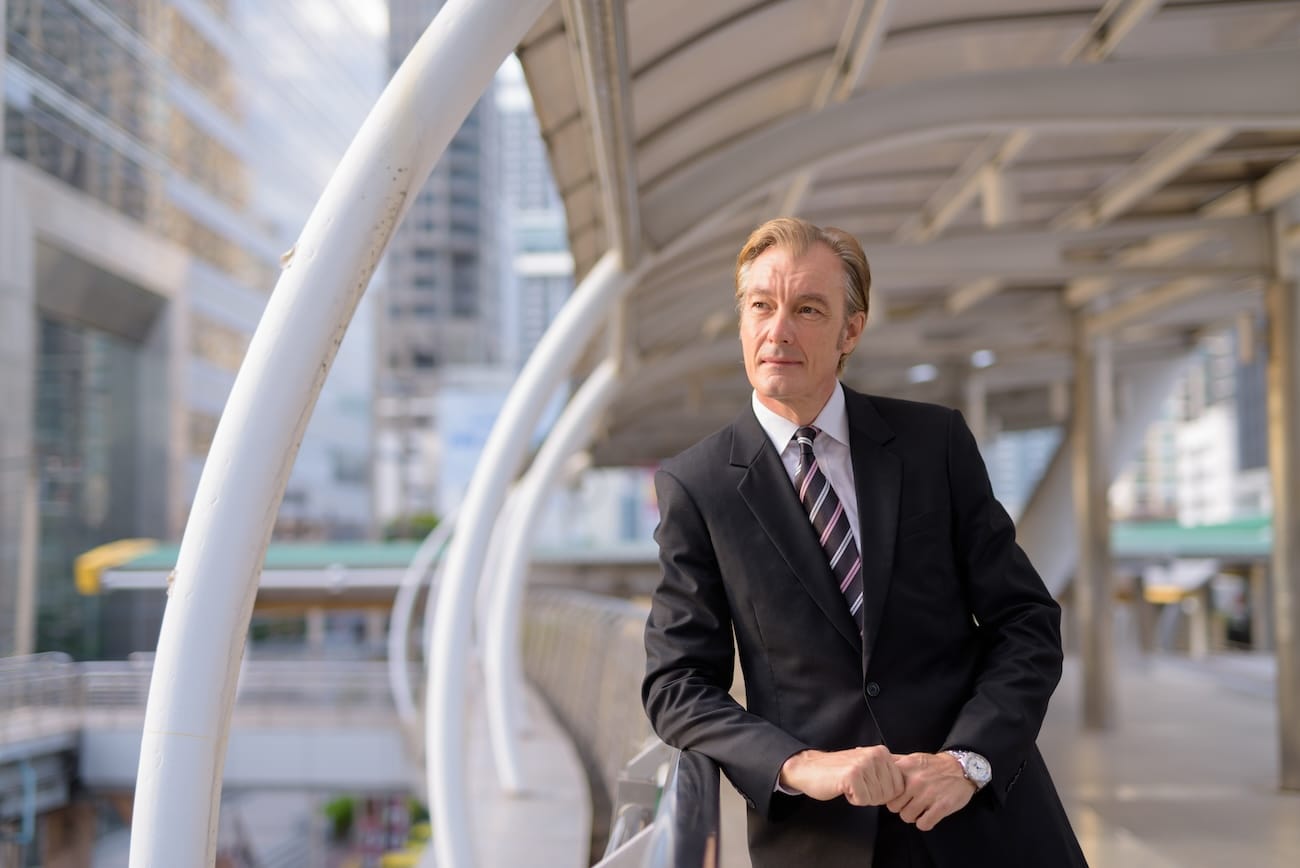 A businessman in a suit on a footbridge, representing the complexities and opportunities of international finance, including Swiss banking for UK clients.