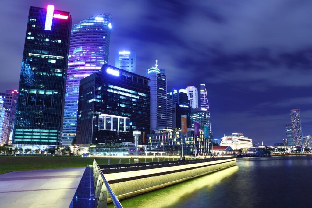 A glowing night view of the Singapore Central Business District skyline and Marina Bay waterfront, a global hub offering premium banking in Singapore for non-residents.