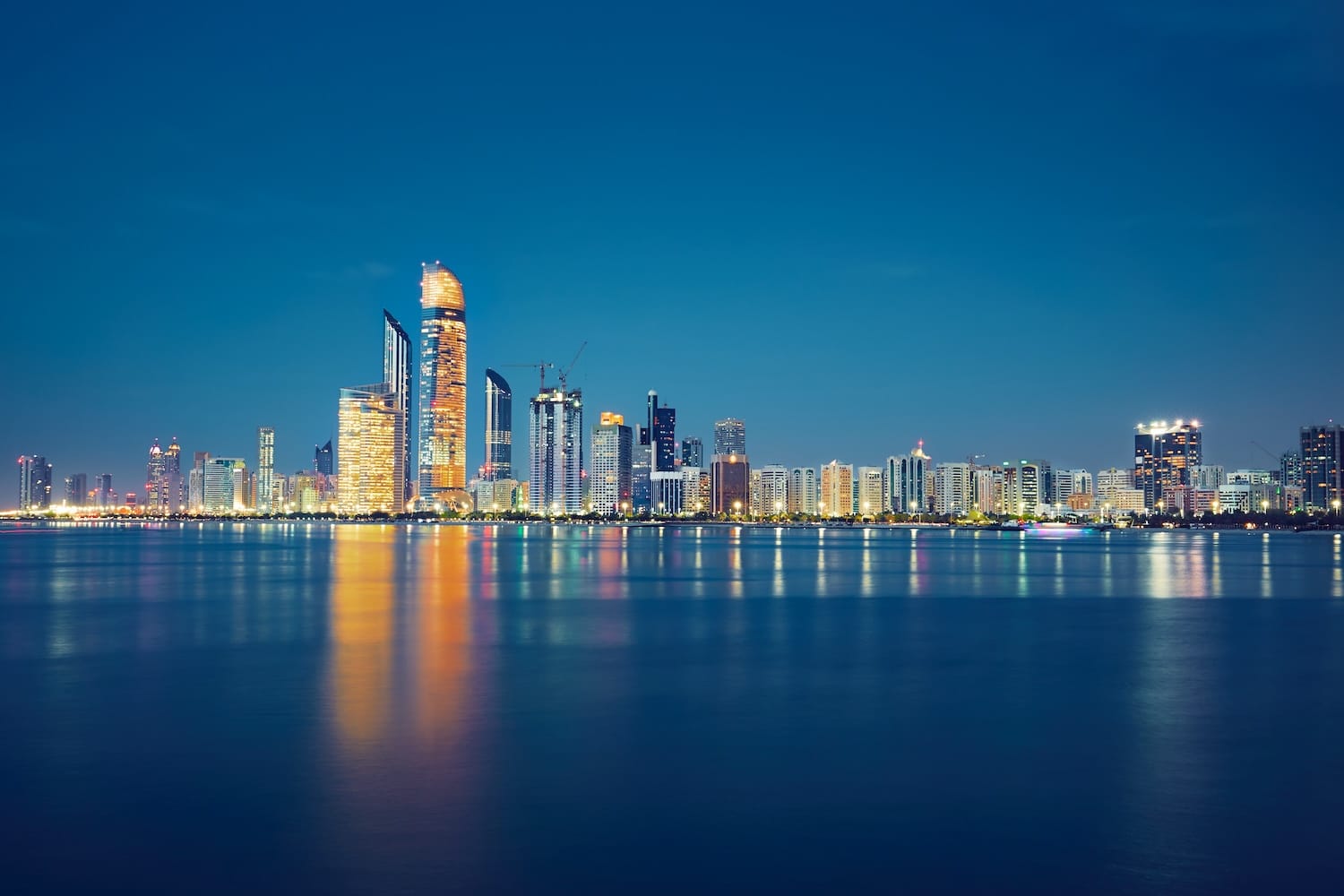 Abu Dhabi skyline at night representing the expansion of Swiss private banking for GCC nationals and wealth management services in the UAE.