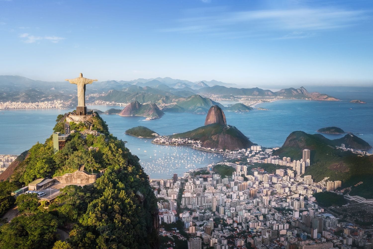 Aerial view of Christ the Redeemer overlooking Rio de Janeiro coastline, symbolizing Swiss private bank account services for Brazilian residents
