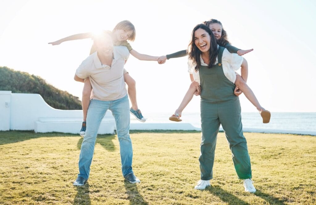 A joyful family playing on a sunny coastal lawn, representing the freedom, security, and high quality of life found in the best countries to relocate for tax free living.