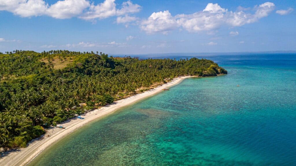 Aerial view of a remote Pacific island coastline, representing the small island nations now offering new citizenship by investment programs